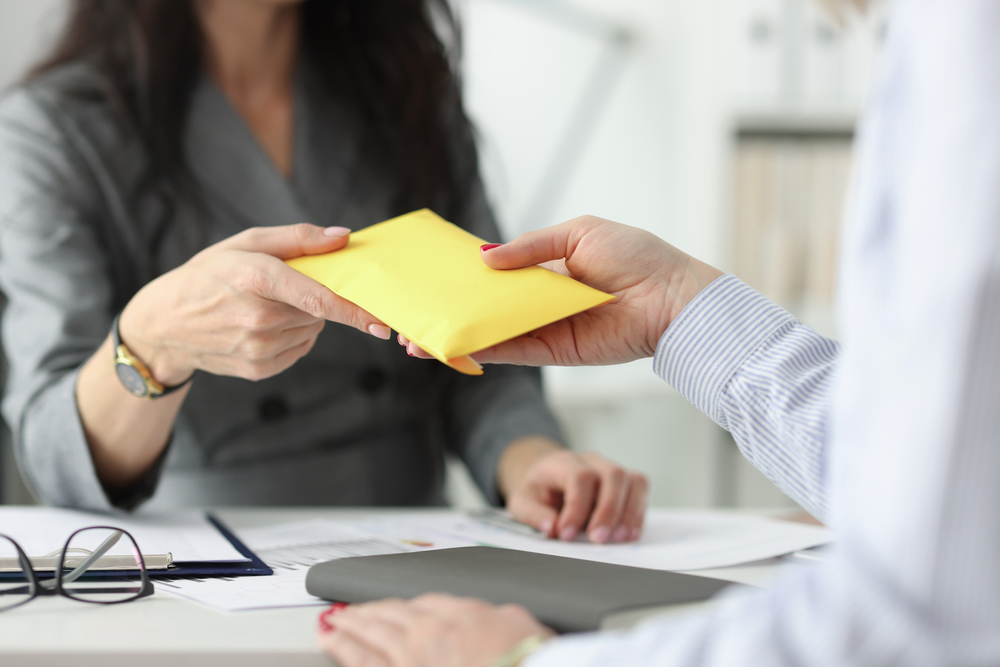 two-people-holding-a-yellow-envelope